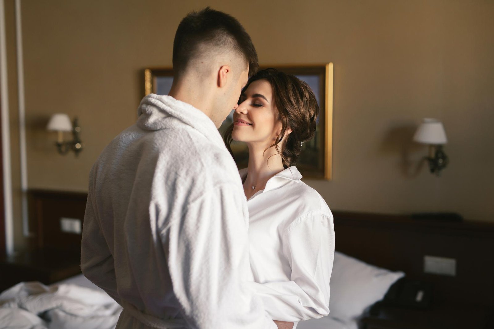 A newlywed couple sharing a joyful hug in a hotel room highlights the importance of intimacy in marriage and the connection between partners.