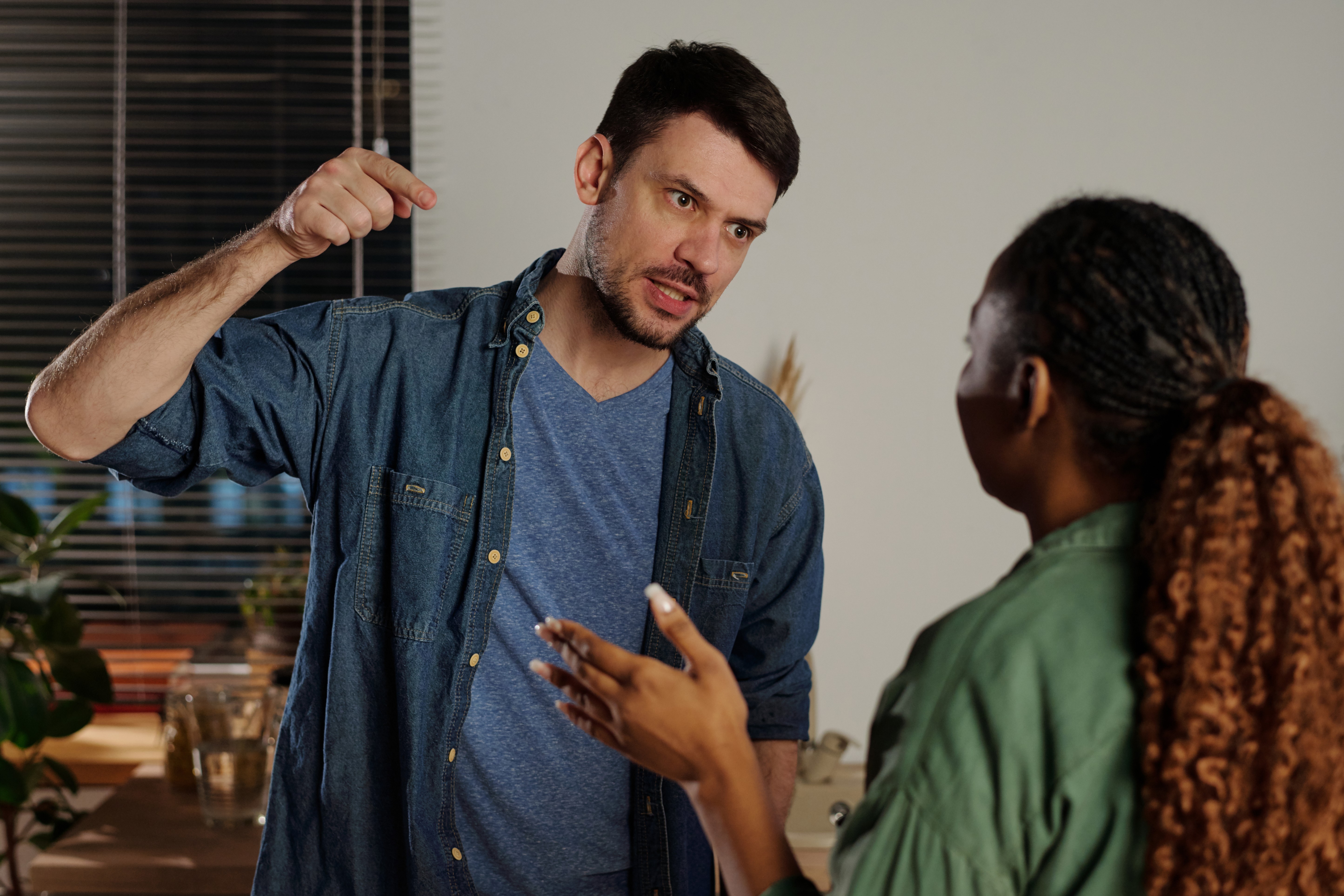 A couple experiencing conflict with an angry person as the man screams at his wife, showcasing a tense emotional moment.