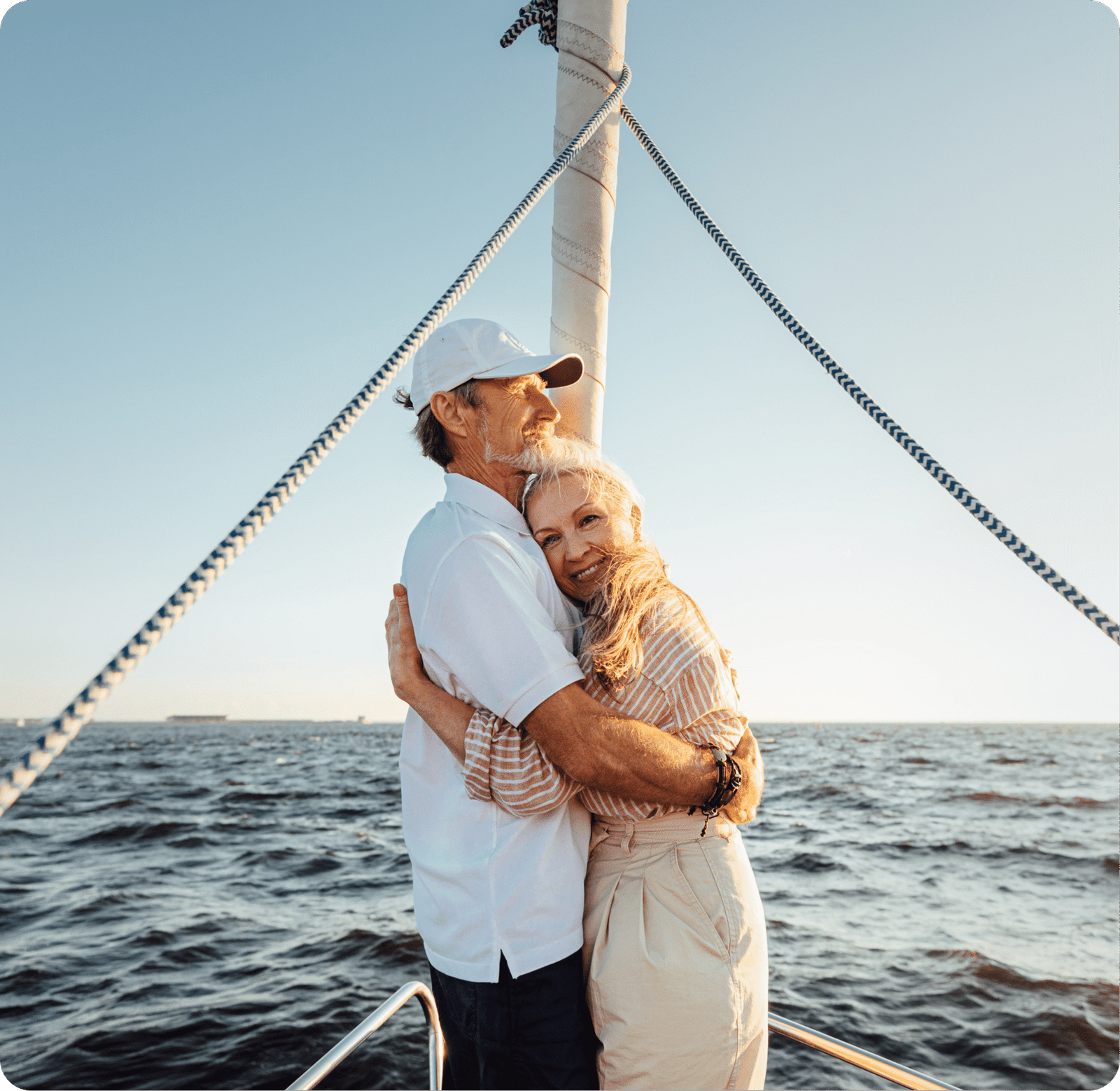 an older couple embracing on a sailing boat
