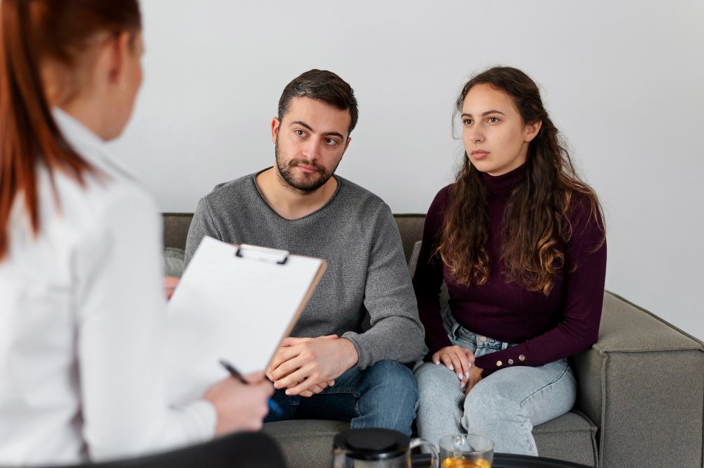 Couple in close-up discussion with a therapist during a private couple therapy session

