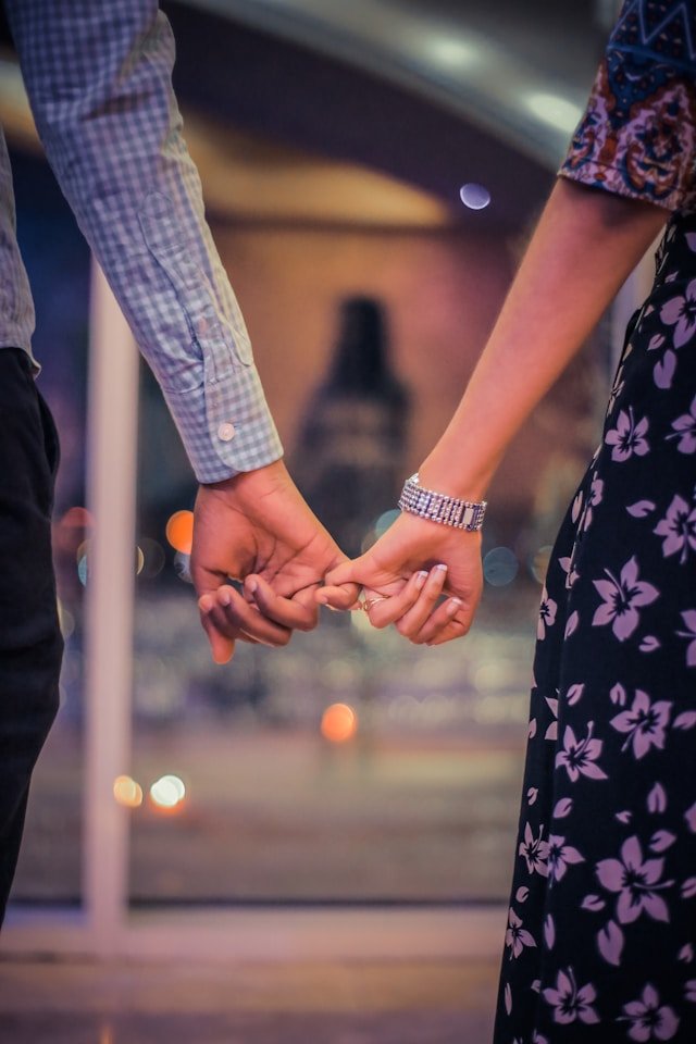 Man and woman sealing a promise by pinky linking 
