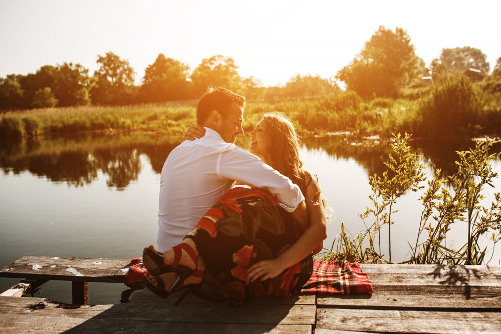  Couple embracing while looking out at a scenic lake, enjoying a peaceful retreat getaway. 