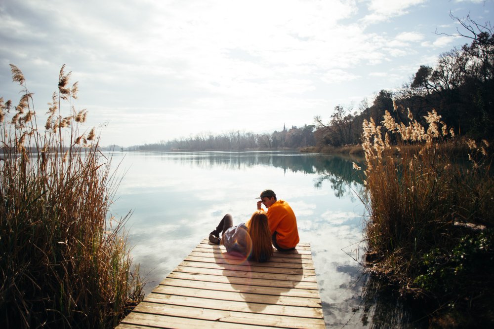  A couple spending a romantic time together on the pier of a scenic lake.
