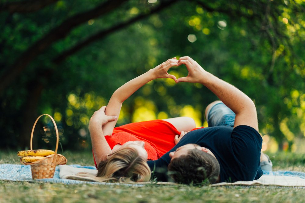 Couple outdoors forming a heart shape with their hands, celebrating love on a couples retreat.