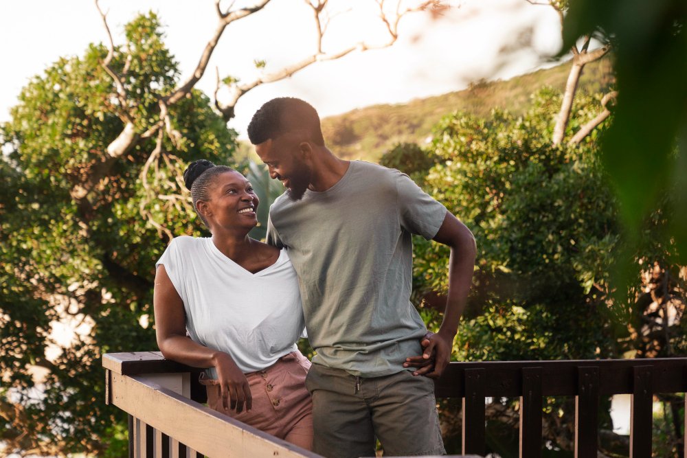 Portrait of a couple smiling together outdoors during a romantic retreat getaway.
