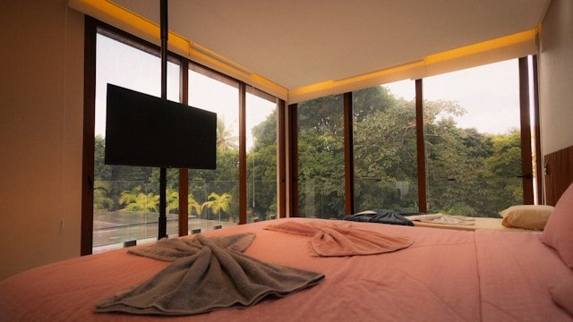 A private bedroom with floor-to-ceiling windows and a lush forest view evoking the calm setting of a marriage weekend retreat