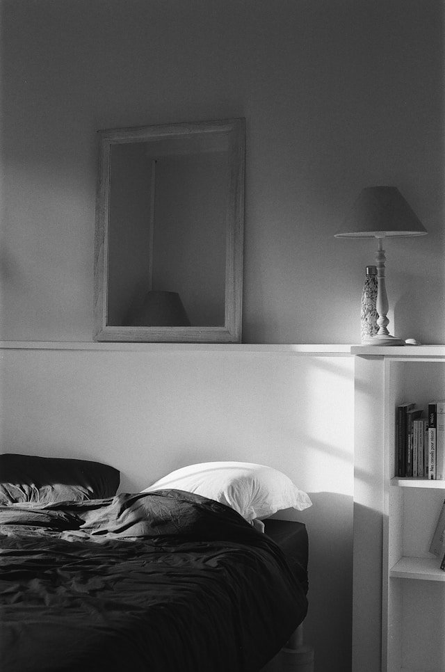 An empty bedroom in black and white, representing the quiet stillness that many parents notice when their children leave home