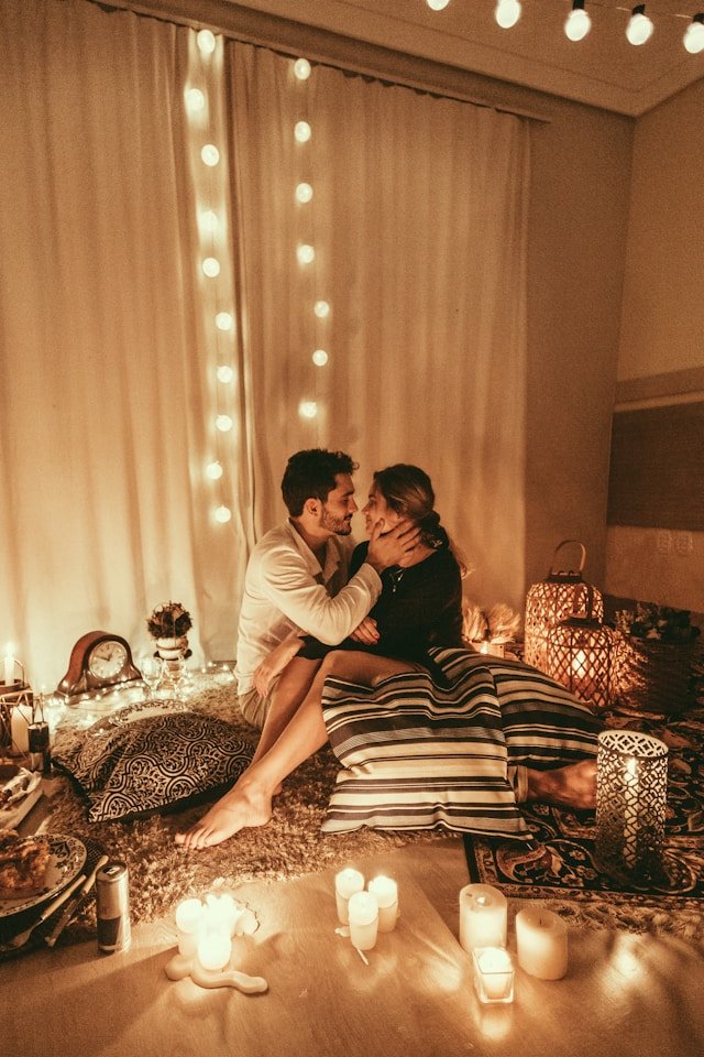 A couple seated close by candlelight in a private room, representing the uninterrupted intimacy of a marriage weekend retreat