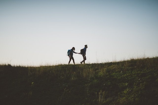 :A couple walking uphill hand in hand, representing the intentional reconnection available to partners who face the empty nest 
