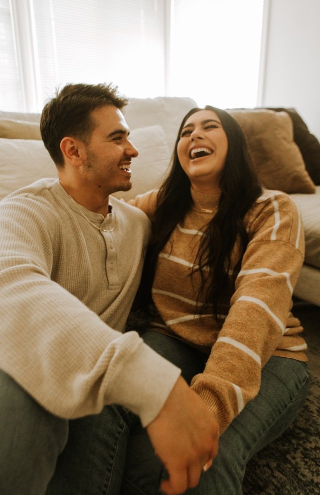 A man and woman laughing together, representing the renewed joy and connection couples can discover after empty nest syndrome 
