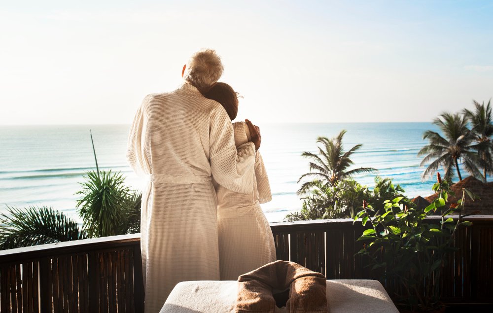 A couple in robes taking in ocean views, showing what to expect on a couples retreat.